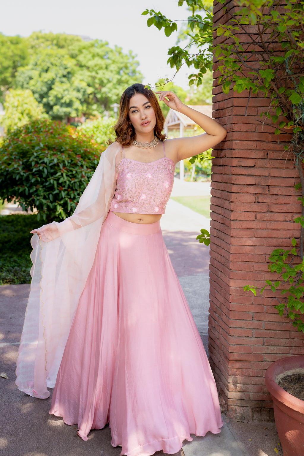 Full view against pillar of Rashi Pink Lehenga Set.