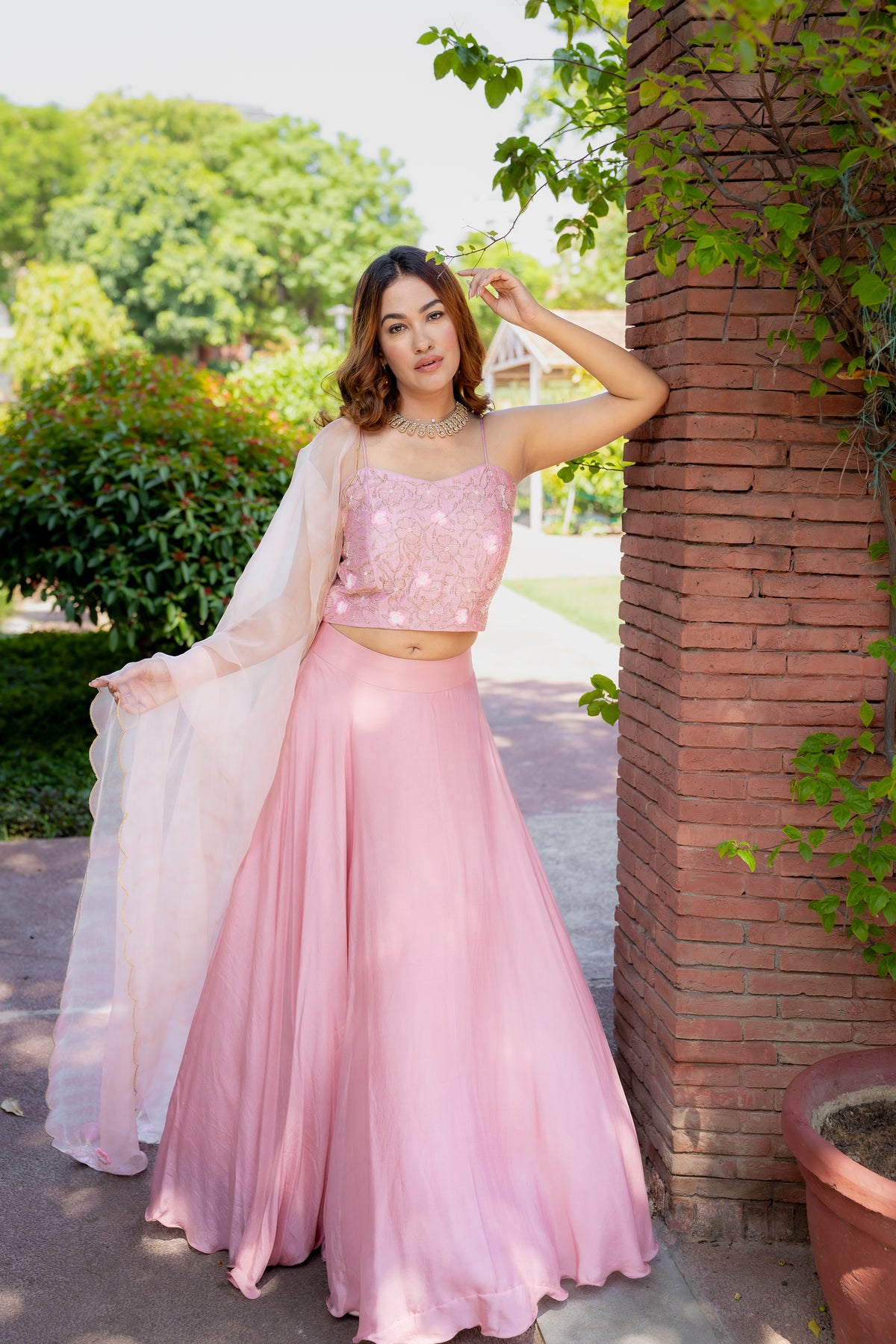 Full view against pillar of Rashi Pink Lehenga Set.
