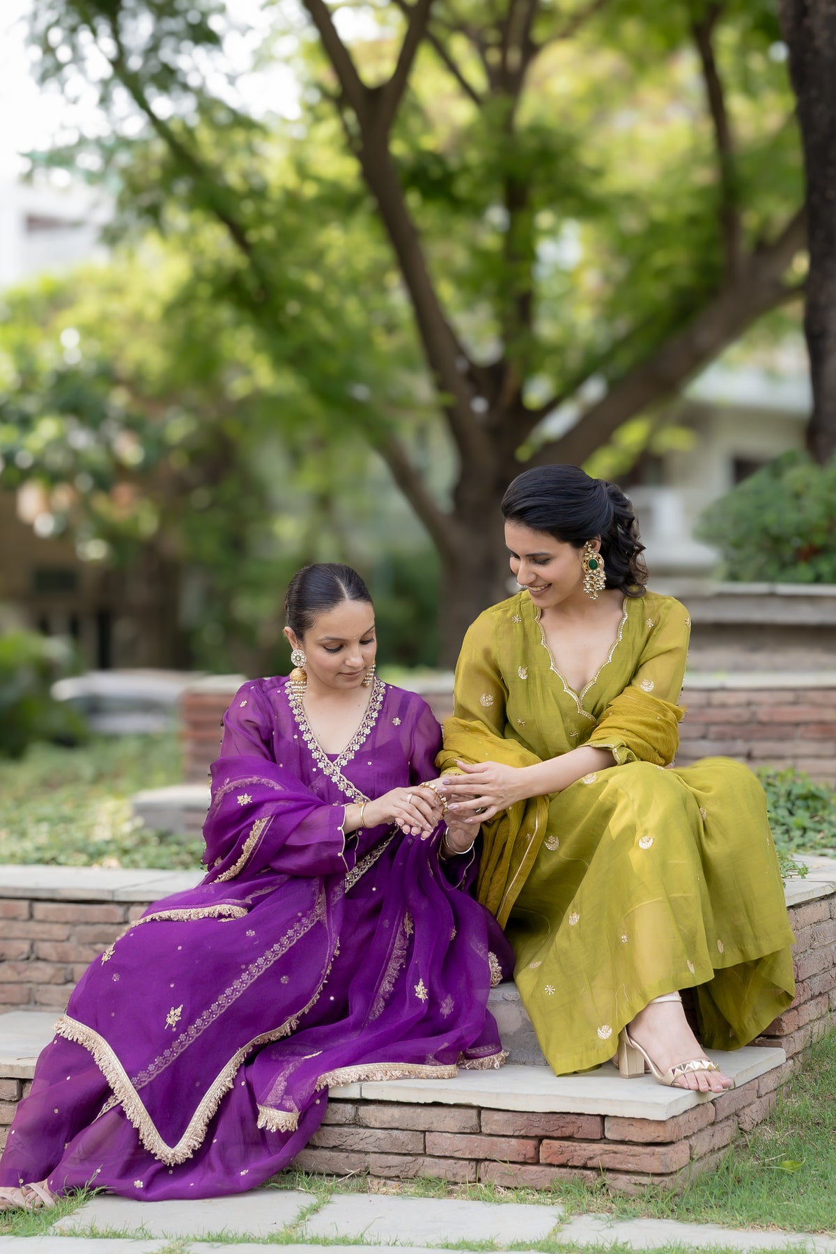 Green sitting view of Poorvi Angrakha Anarkali Set.