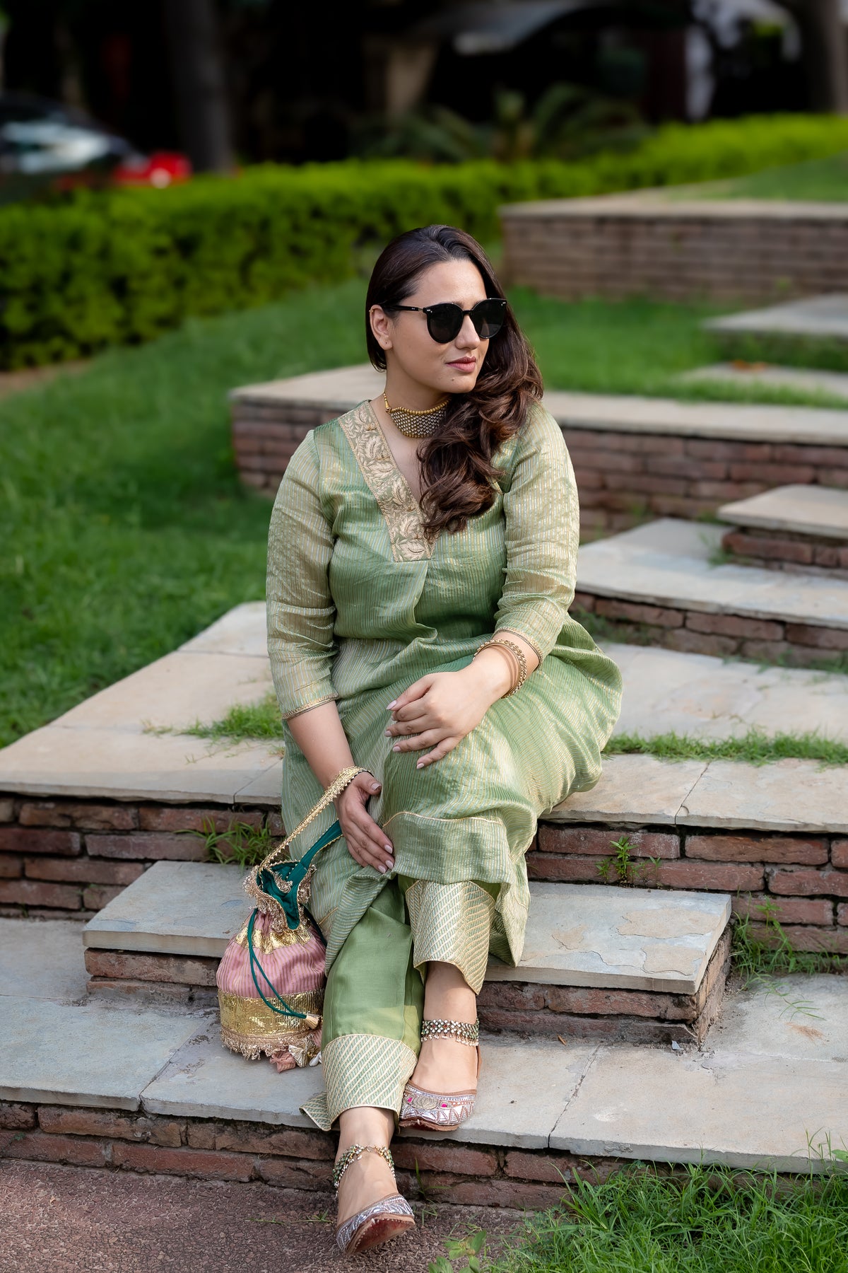 Close-up shot of the model sitting in green chanderi kurta set.