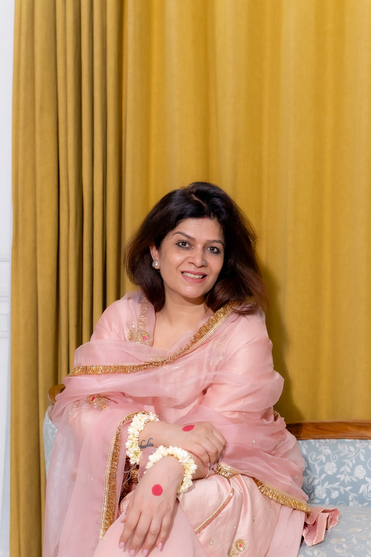 Front view of model sitting in a pink chanderi silk kurta set