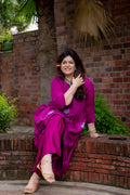 Front view of model sitting pose in preet bandhej magenta kurta set