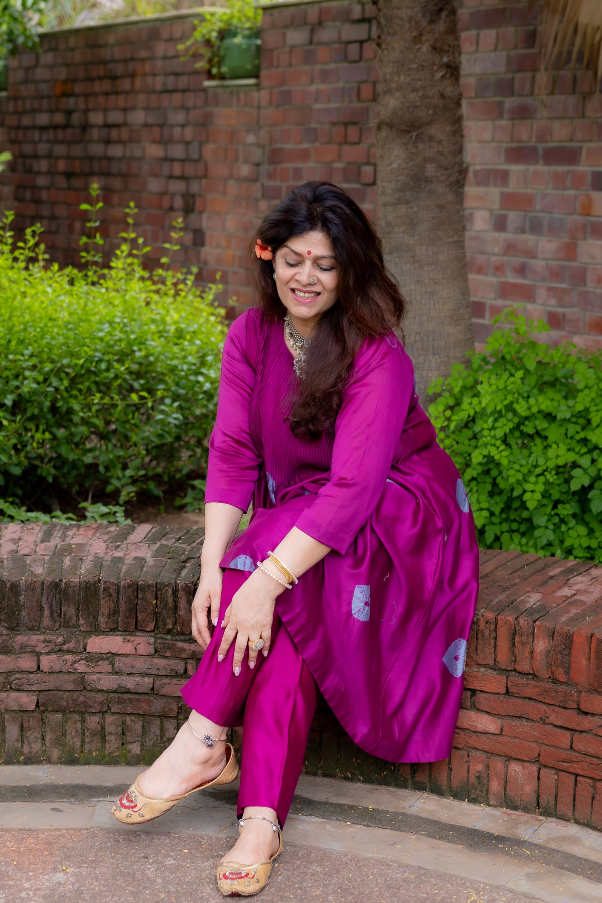model sitting view of preet bandhej magenta kurta set