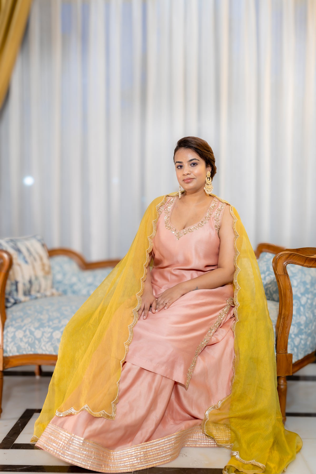 Sitting view of Gulnaar Peach Kurta Set with Mustard Dupatta.